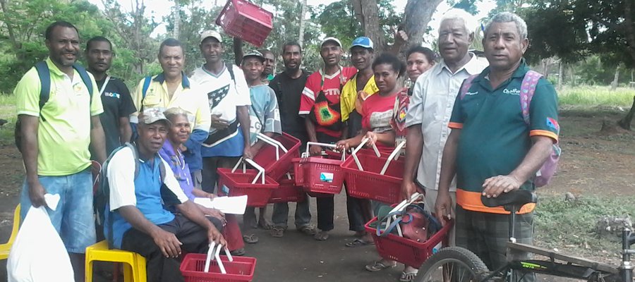 Members of the community stand together with baskets containing crabs