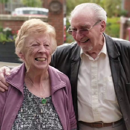 A photo of an older, white couple laughing together