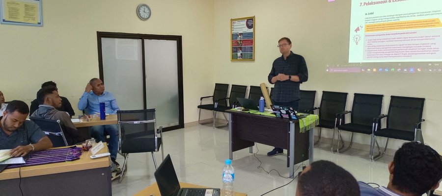 A classroom environment in Timor-Leste, with a trainer at the front