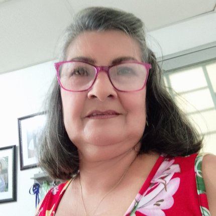 A woman with purple-rimmed glasses takes a selfie