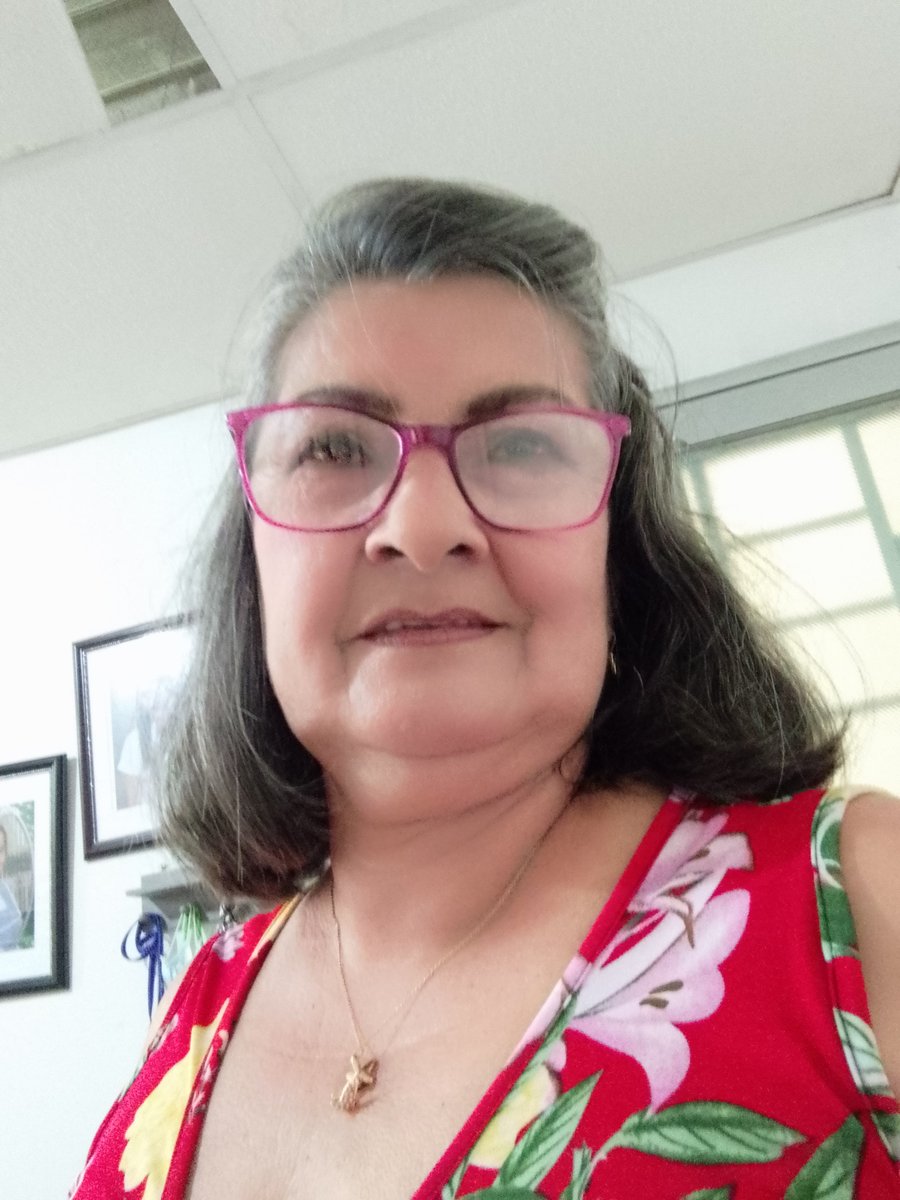 A woman with purple-rimmed glasses takes a selfie