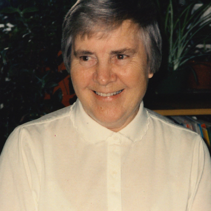 A photo from the late 1980s/early 1990s of a woman with short grey hair in a white shirt