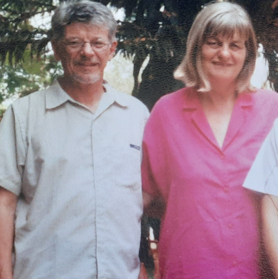 A man in a white shirt and a woman in a pink shirt look to camera