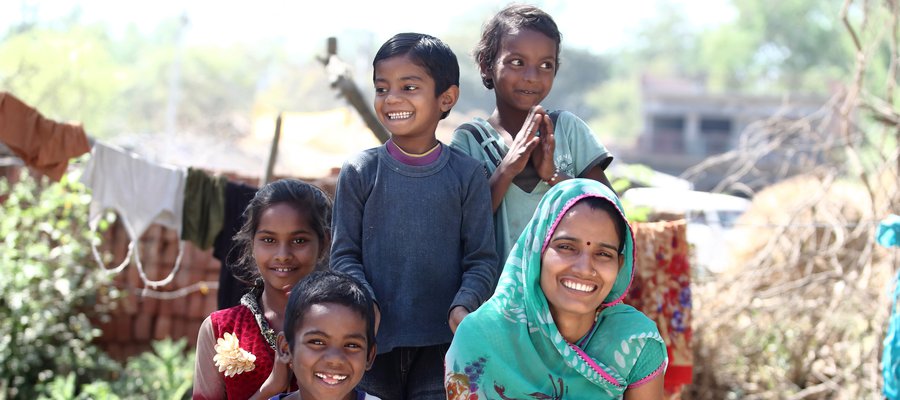 Parma (pictured here with smiling children) is a volunteer with TLM Trust India.