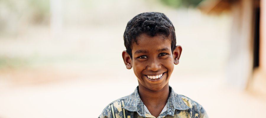 A young man affected by leprosy in Sri Lanka smiles at the camera