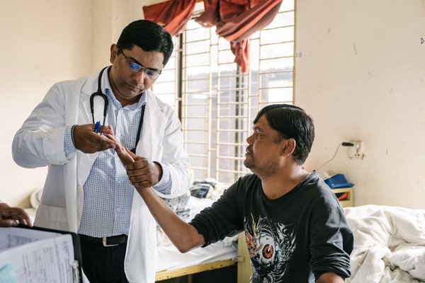 Dr Benjamin examines a patient at DBLM Hospital in Bangladesh