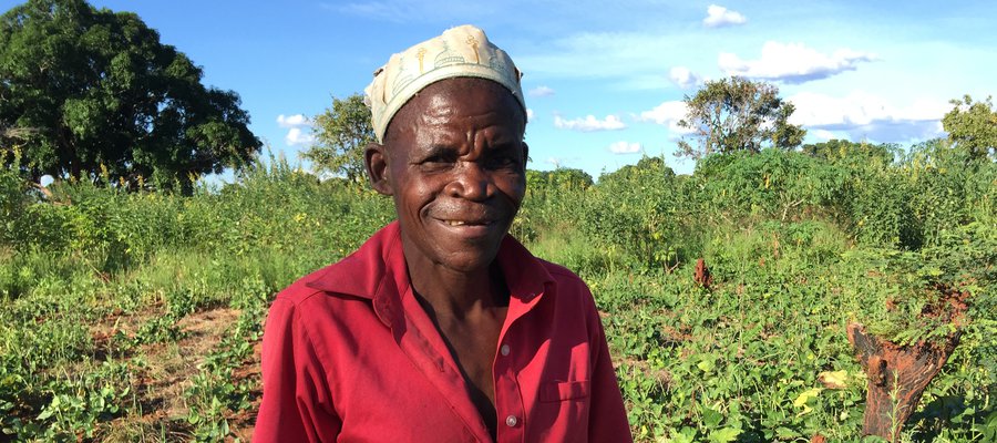 Armando stands in front of fields in his farm