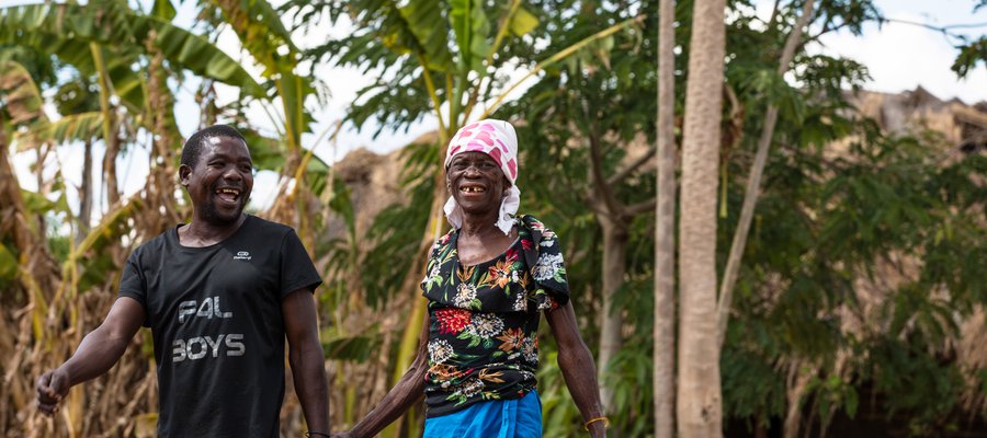 Two people hold hands in a village in Mozambique