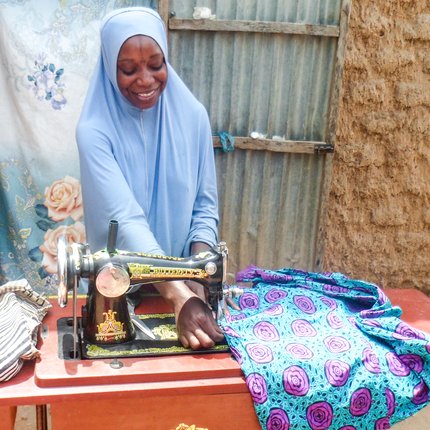 Mariama has received job training and is a skilled seamstress making clothes to sell