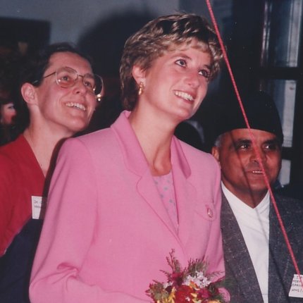 Diana, Princess of Wales, wearing pink and holding a bouquet of flowers, visits TLM's Anandaban hospital in Nepal