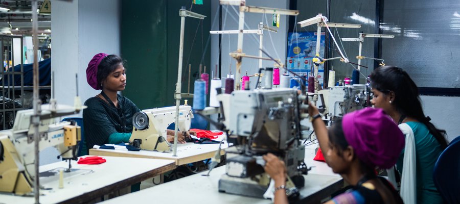 Three young women in India working at sewing machines