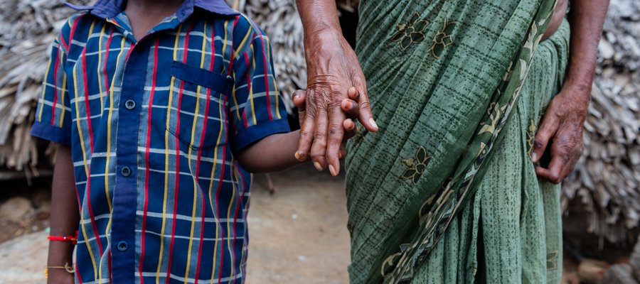 A shot of a young boy and woman holding hands