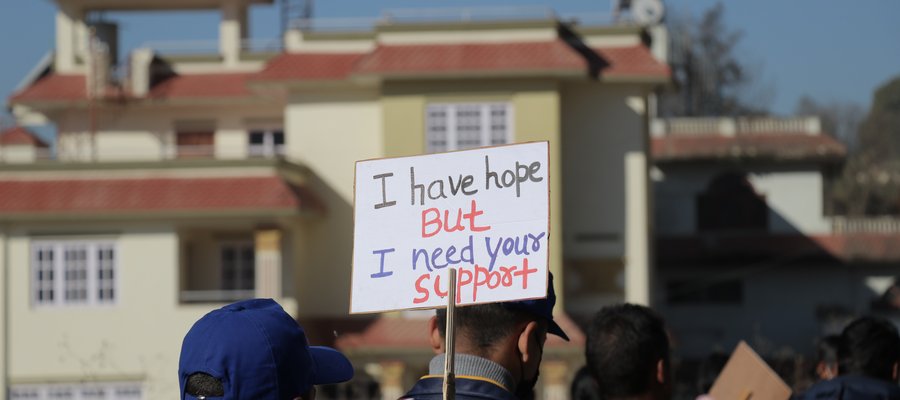 At a World Leprosy Day march, someone carries a banner that reads 'I have hope, but I need your support'
