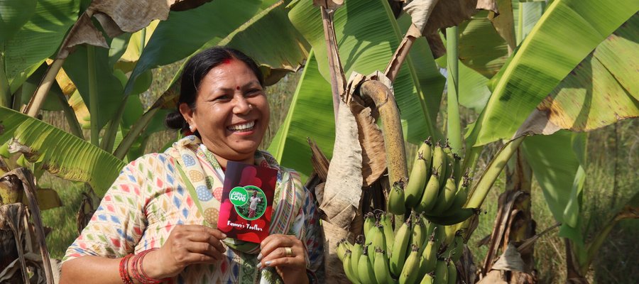 A woman holding a bag and smiling at the camera.