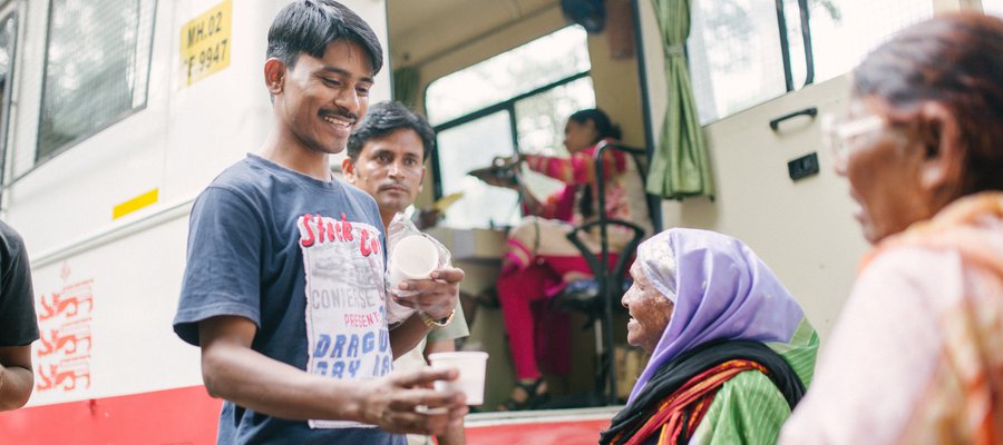 Karuna Mobile Clinic - people share cups of chai together at the clinic