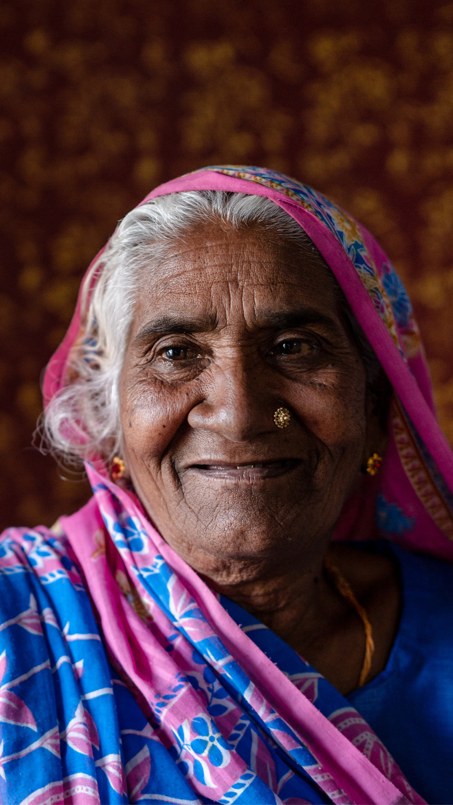 A woman from Nepal in a headscarf looks at the camera