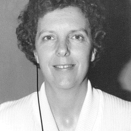 A black and white photo of a woman with short hair in a white cardigan
